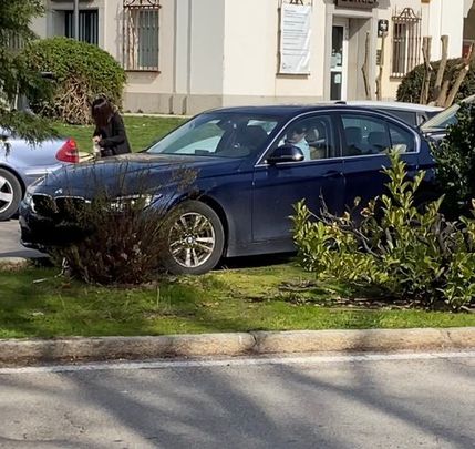 Un conductor trata de aparcar su coche sobre una mediana en el centro de El Pardo / AV EL PARDO