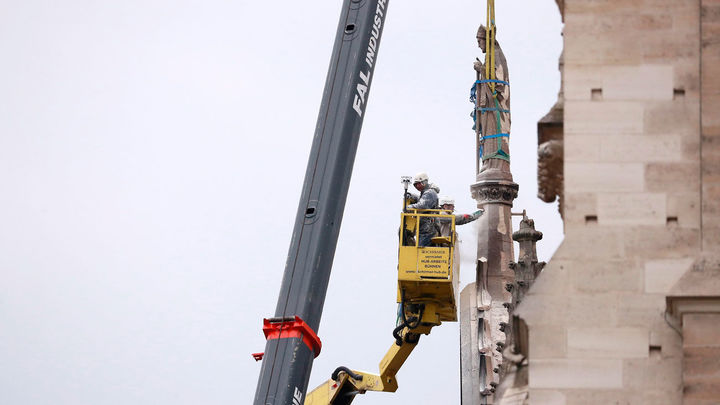 Operarios retiran una estatua de la catedral de Notre Dame como medida de prevención después del incendio / EFE
