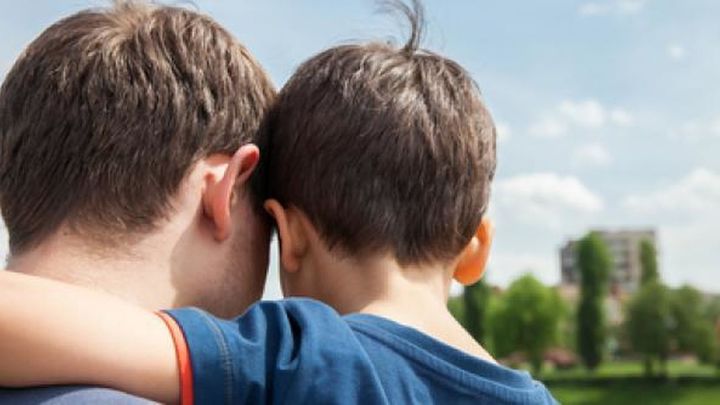 Un menor en brazos de su padre / Telemadrid.es