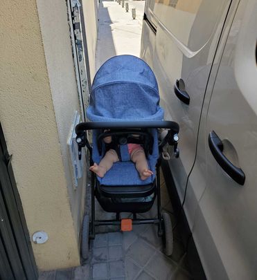 Un carrito de bebé encajonado en la acera de una calle / AV PUERTA DEL ÁNGEL