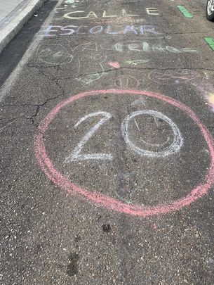 Dibujo con tiza en el asfalto pidiendo la reducción de velocidad en la calle del colegio / AFA ASUNCIÓN RINCÓN