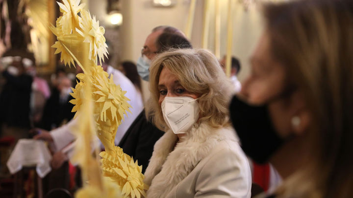 Feligresas con ramos de palma en la misa del domingo de ramos de la Hermandad de la Borriquita en su sede, la parroquia de San Ildefonso, en Madrid (España), a 28 de marzo de 2021. / EUROPA PRESS