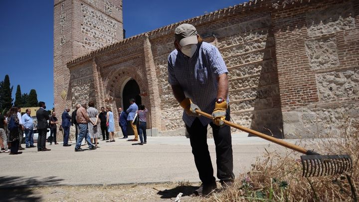 Vecinos limpian el exterior de la iglesia mientras la comitiva oficial acude a ver el fresco gótico / JUAN GARCÍA