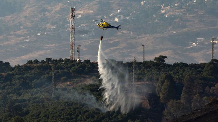 Un helicóptero trabaja en las tareas de extinción del incendio de la localidad malagueña de Mijas / EFE