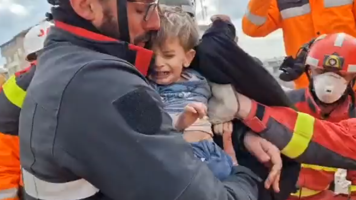 Un miembro de la UME abriga al pequeño tras ser rescatado 4 días después del seísmo / DEFENSA