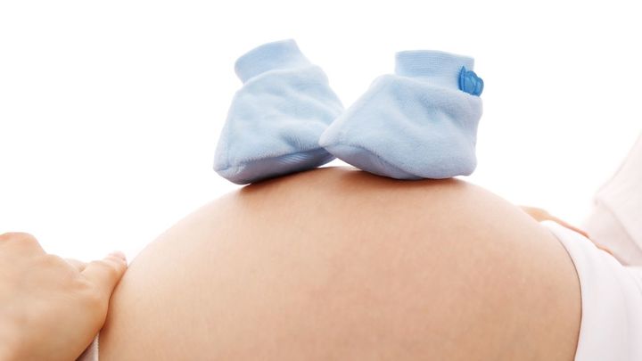 Una mujer embarazada con unos patucos azules / DOMINIO PÚBLICO