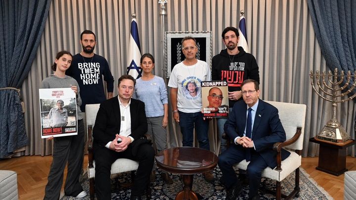 Elon Musk posa junto al presidente israelí Isaac Herzog para una foto con representantes de las familias de los rehenes retenidos por Hamás / Haim Zach/GPO/dpa