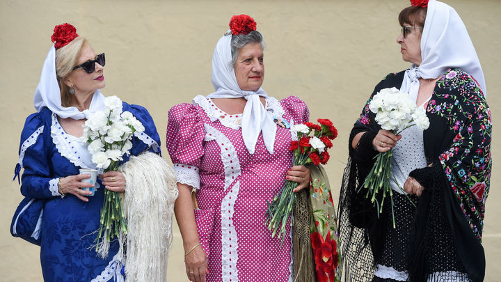 Mujeres vestidas de chulapa repartiendo claveles / EUROPA PRESS