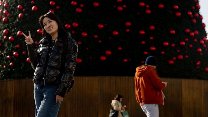 Una turista se hace una foto junto al árbol de Navidad de la Puerta del Sol, / EUROPA PRESS