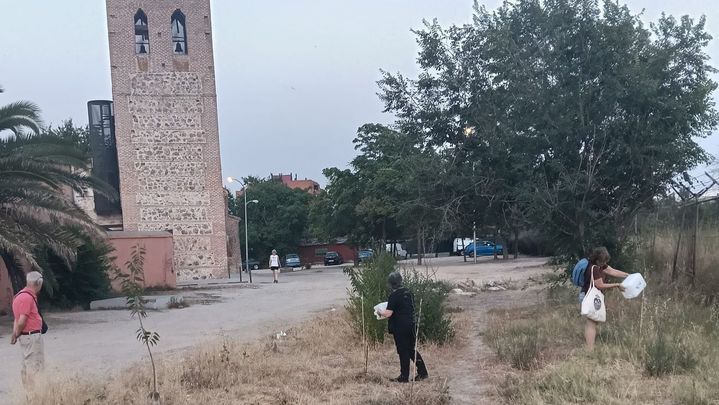 Varias personas riegan los árboles próximos a la Ermita de Santa María La Antigua, en Carabanchel / JUAN GARCÍA VICENTE